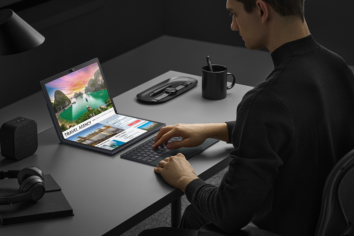 Zenbook 17 Fold OLED als Notebook mit halb gefaltetem Display vor einem Anwender auf dem Tisch