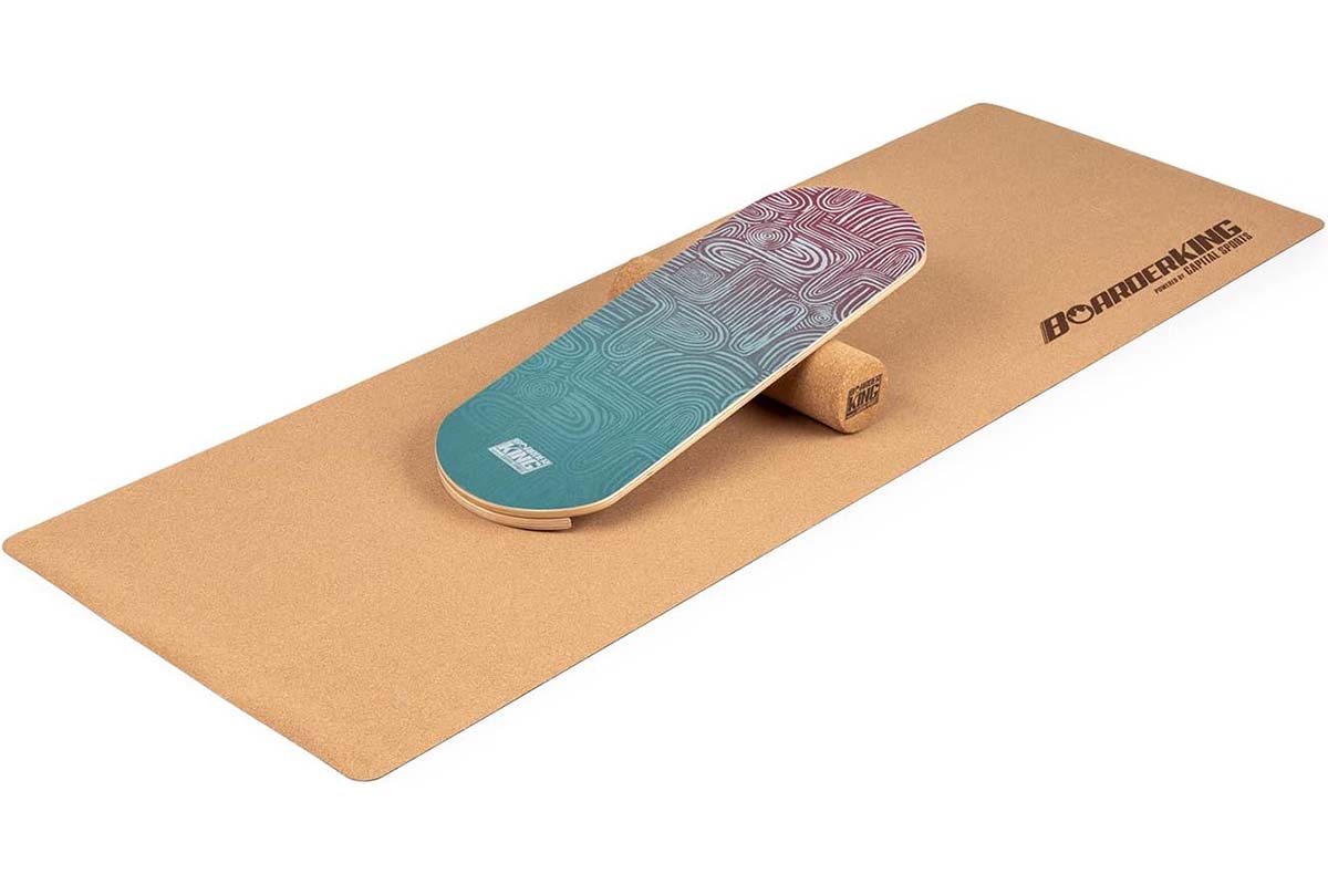 Balance Board darunter eine Korkrolle und Matte auf weißem Grund