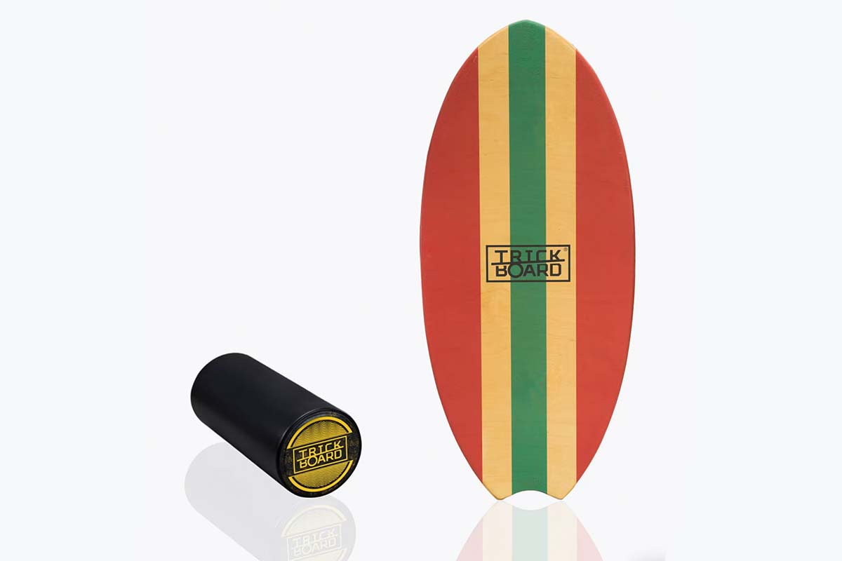 Bunt-gestreiftes Balance Board, daneben eine Korkrolle auf grauem Grund