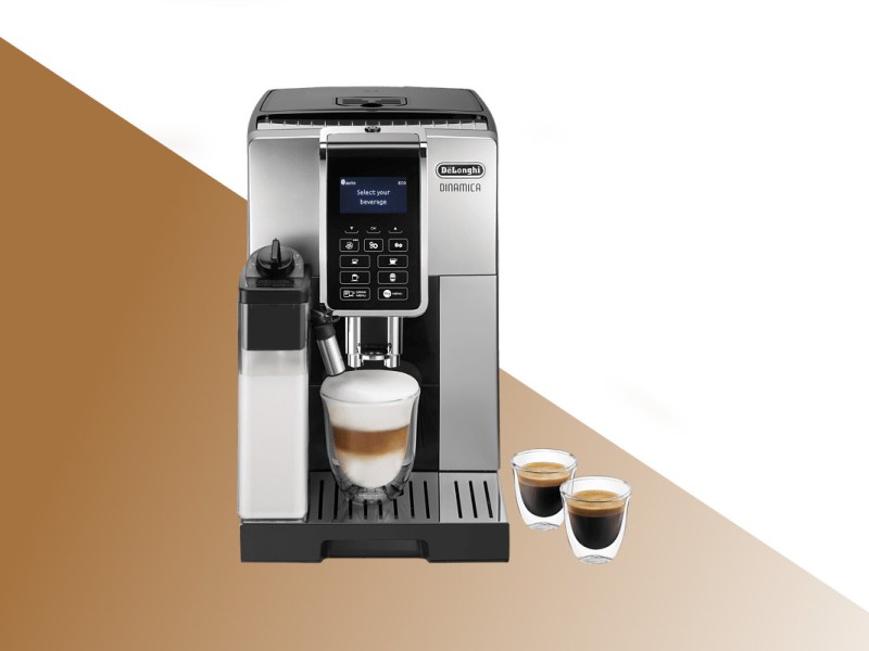 Silbern schwarzer De'Longhi-Kaffeevollautomat von vorne mit Glas mit Kaffee, daneben zwei weitere Kaffeegläser auf weißem Hintergrund mit braunem Verlauf unten
