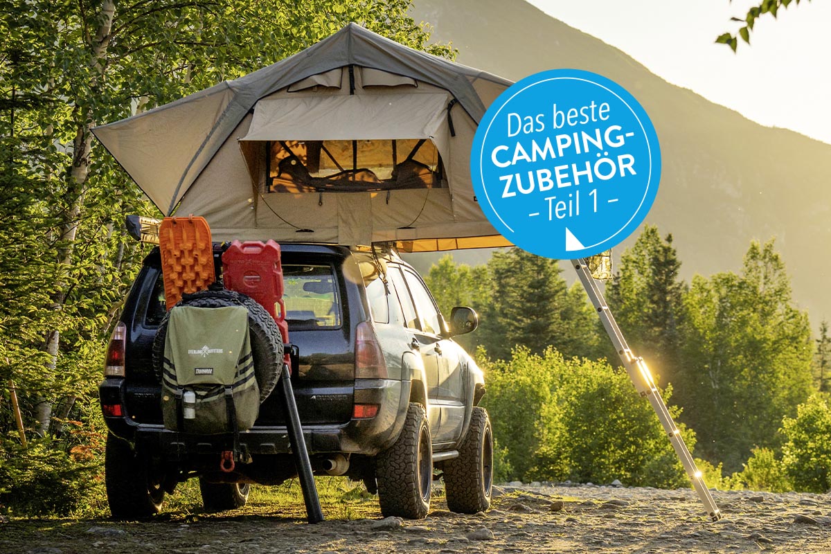 Ein Zelt steht über einem Geländewagen in freier Natur.