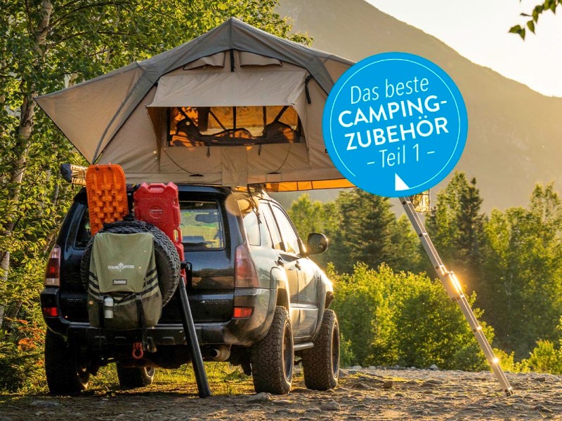 Ein Zelt steht über einem Geländewagen in freier Natur.