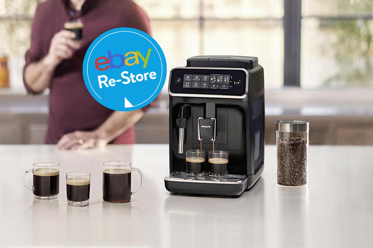Schwarzer Philips-Kaffeevollautomat auf Küchentheke mit Espressogläsern davor, dahinter Mann verschwommen