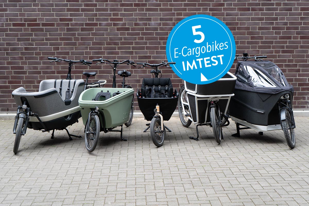 Fünf E-Cargobikes aufgereiht auf Pflastersteinen.