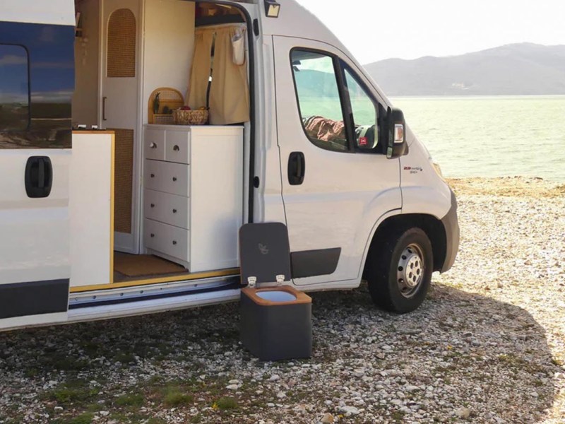 Trelino Toilette vor einem Camper, der am Wasser steht