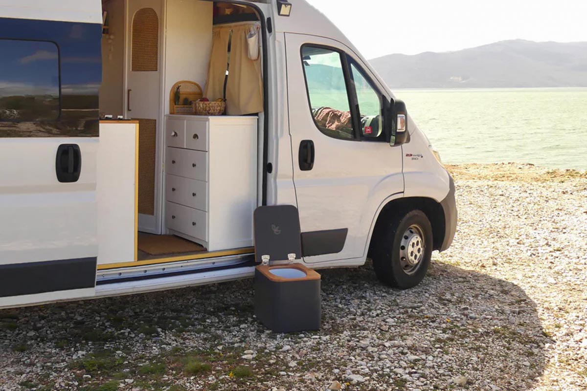 Trelino Toilette vor einem Camper, der am Wasser steht