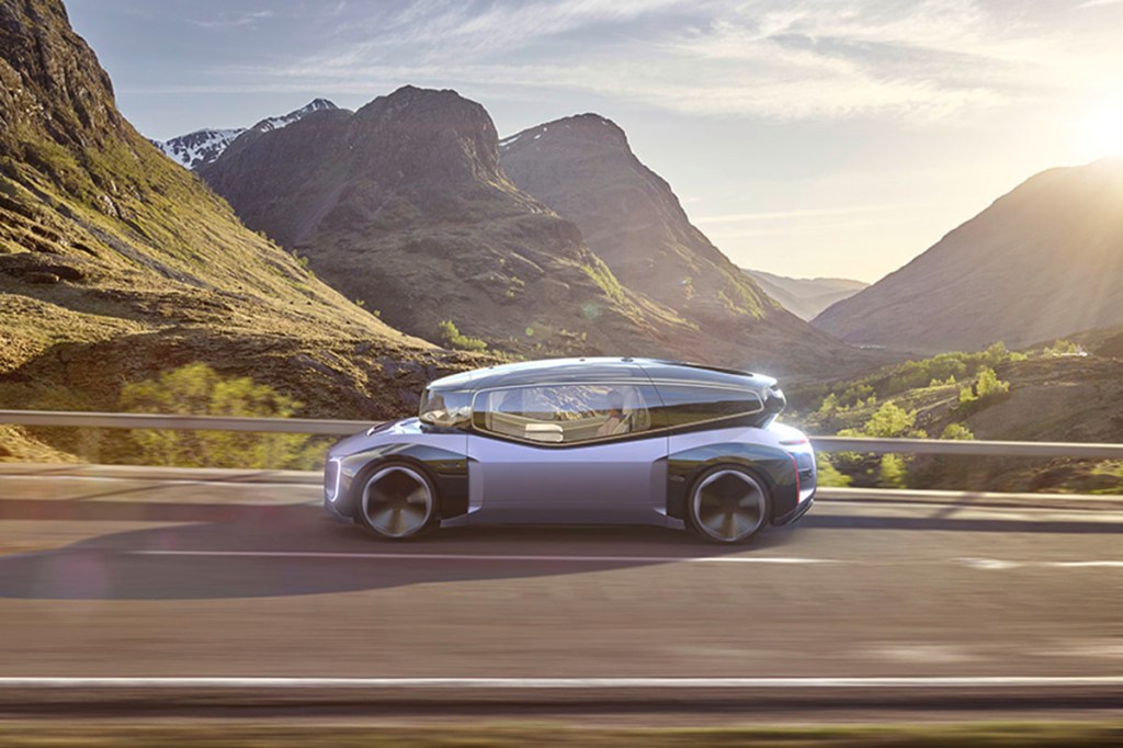 Die autonom fahrende E-Auto-Designstudie  GEN.TRAVEL von VM bei einer Fahrt über eine Straße in gebirgiger Landschaft.