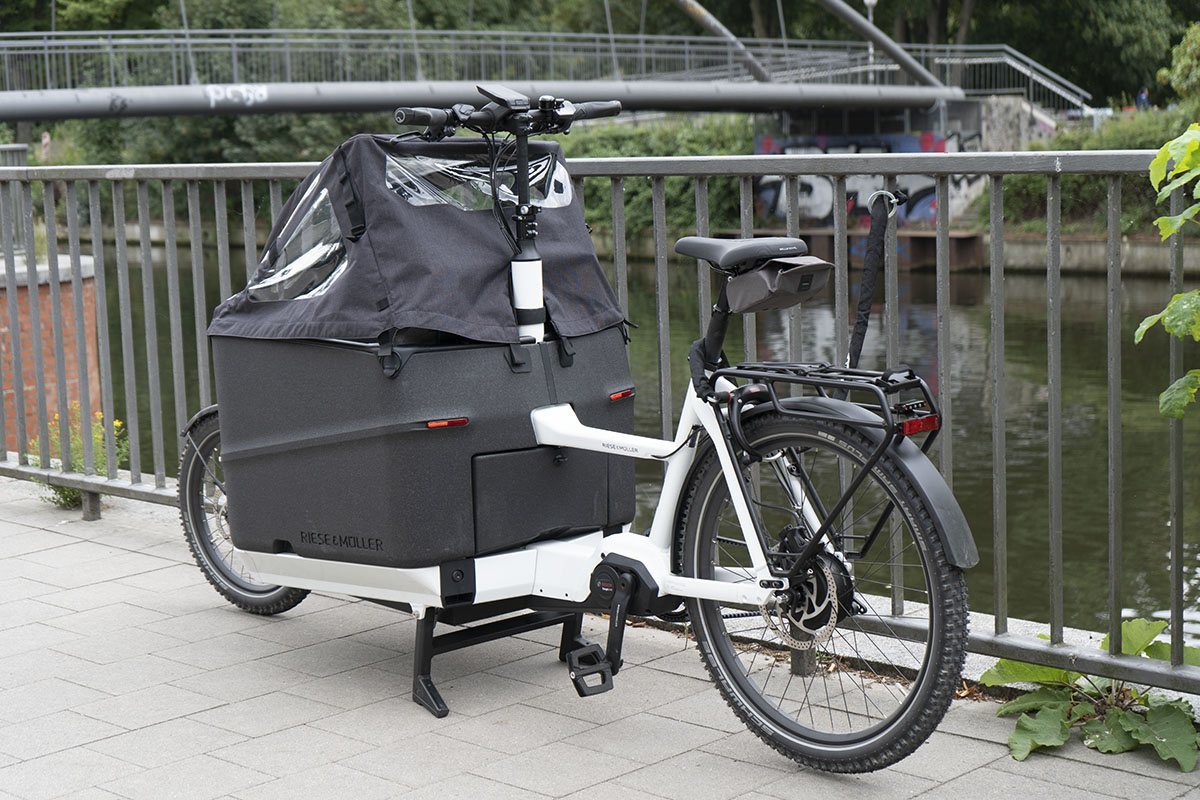 E-Cargo-Bike steht angeschlossen vor einem Geländer.