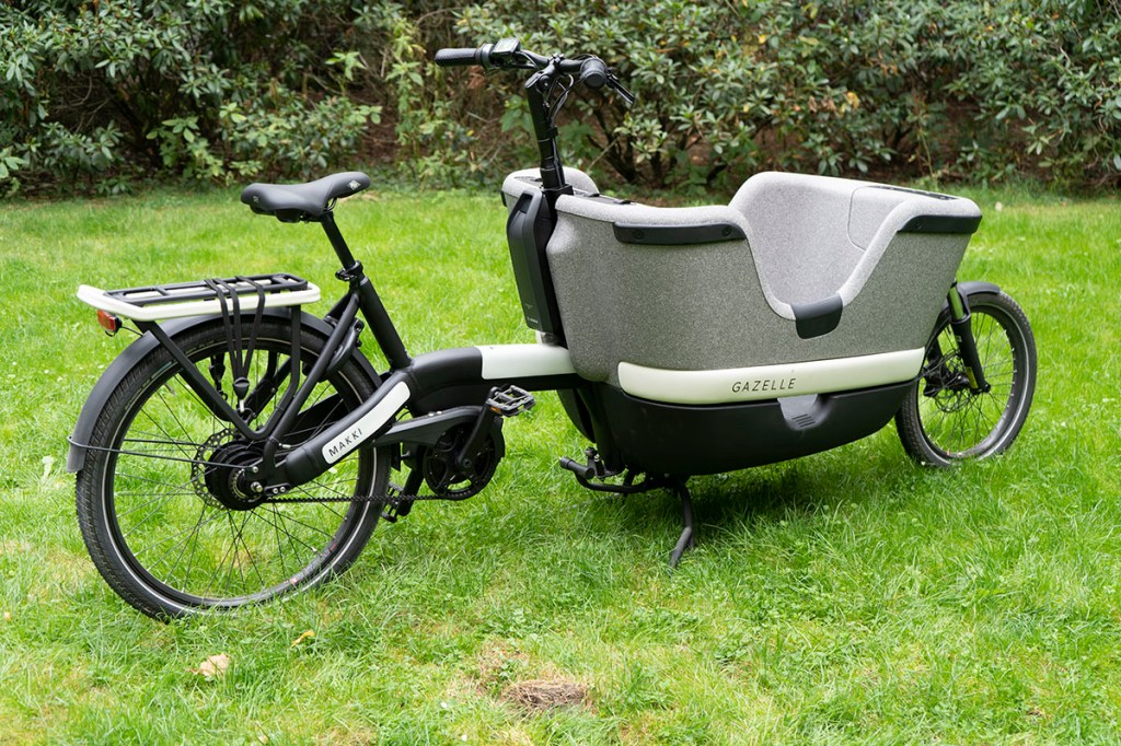 E-Cargo-Bike von Gazelle in Seitenansicht vor einem Park.