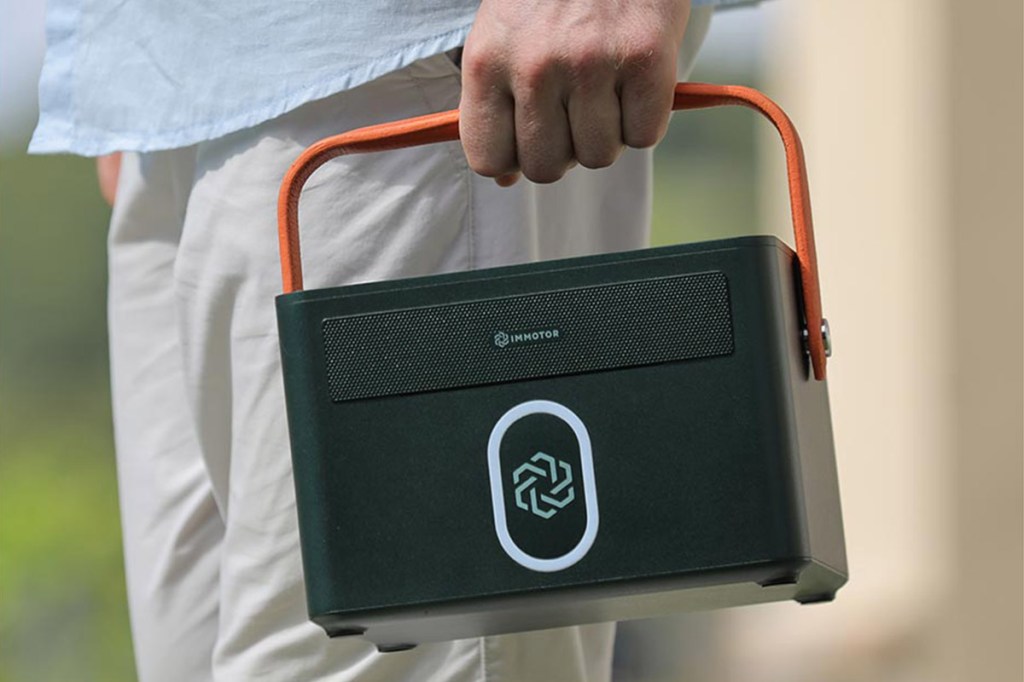 A person carries an Immotor Bay Power Station.