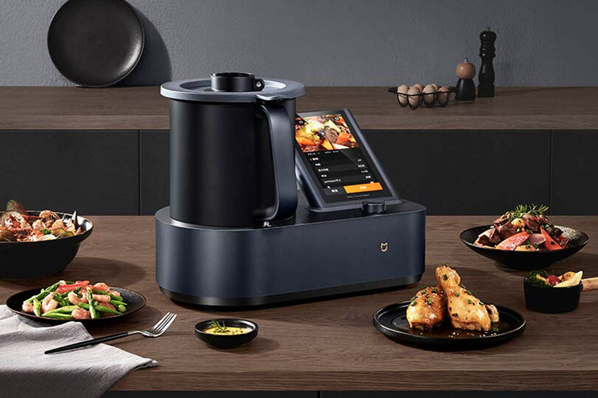 Der neue Mijia Cooking Robot steht in einer Küche. Um ihn herum stehen verschiedene Speisen.