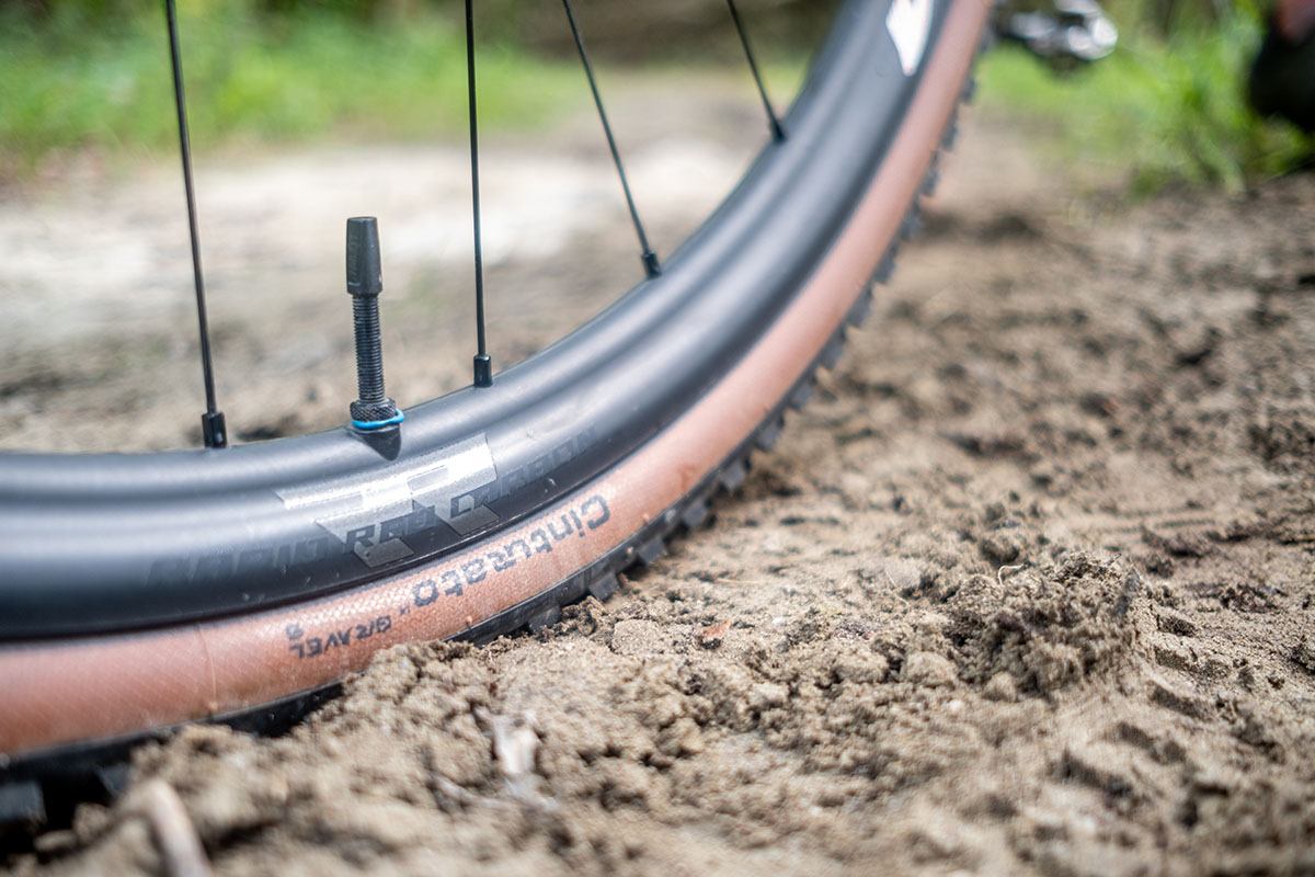 Nahaufnahme eines Pirelli-Reifens für E-Gravel-Bikes bei einer Fahrt über unwegsamen Boden.