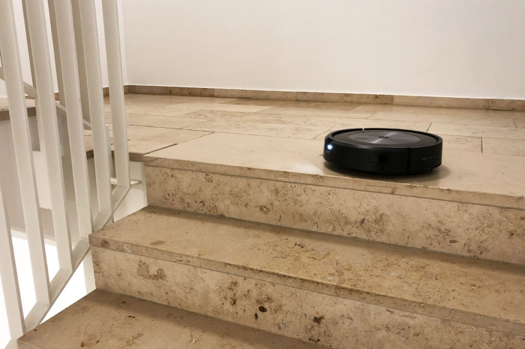 Der Roomba vor einem Treppenabsatz.