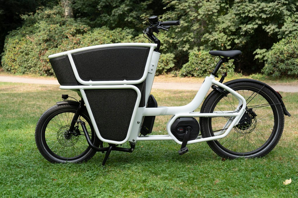 E-Cargo-Bike von Urban Arrow in Seitenansicht vor einem Park.