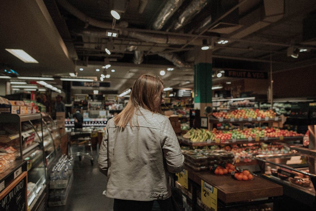 Eine Frau läuft durch einen Supermarkt.