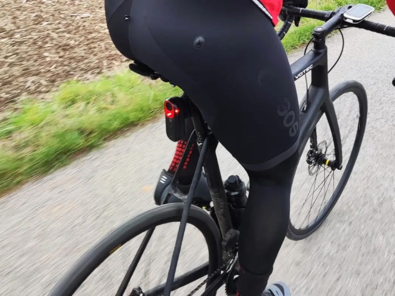 Person von hinten im Anschnitt auf einem Rennrad, am Sattelrohr ist ein Radar befestigt