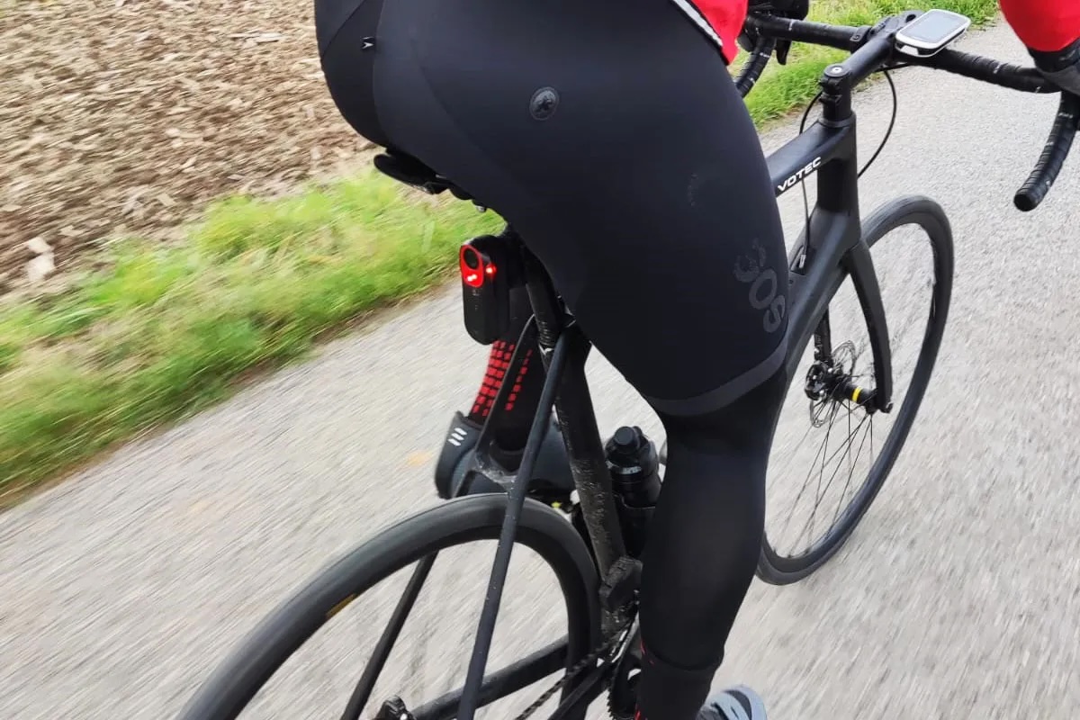 Person von hinten im Anschnitt auf einem Rennrad, am Sattelrohr ist ein Radar befestigt