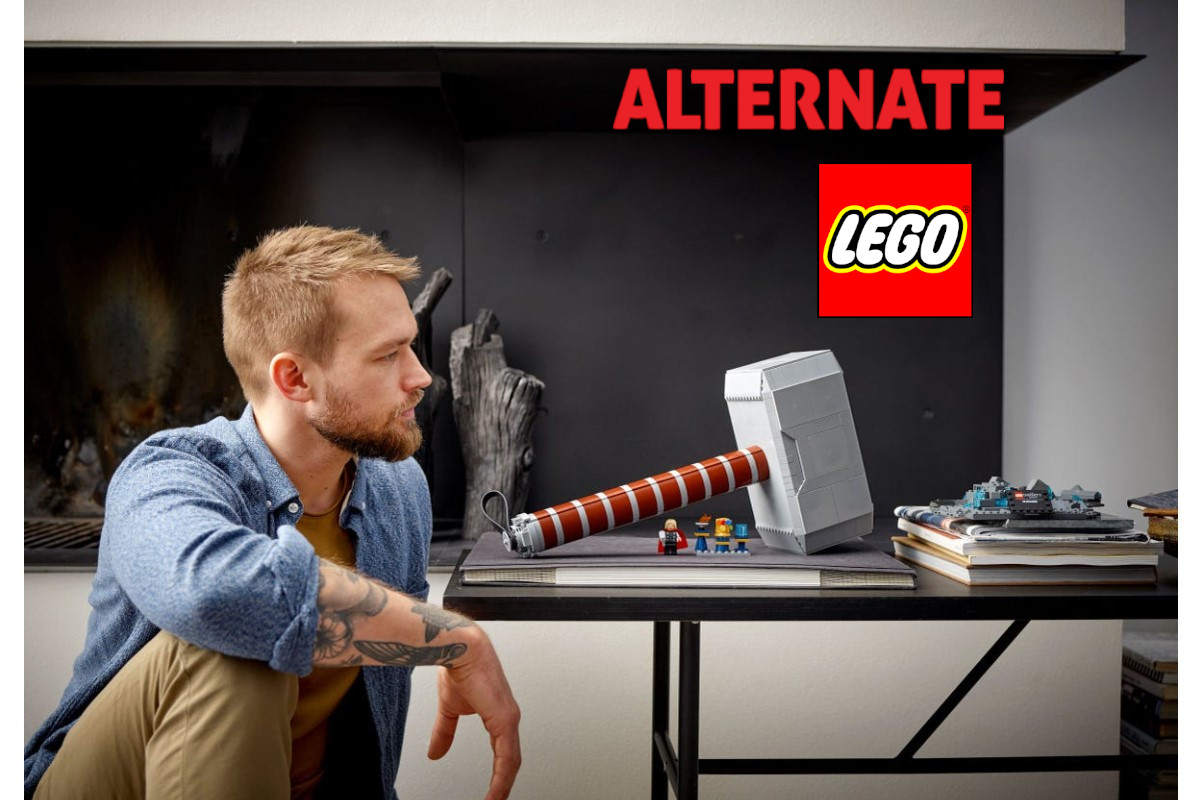mann sitzt vor Tisch auf dem LEGO Nachbildung von Thors Hammer steht mit Lego Logo und Alternate Logo rechts