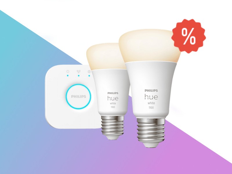 Zwei weiße Philips Hue Leuchten vor weißer Bridge auf weißem Hintergrund mit blau lila Verlauf unten und rotem Prozentzeichen oben rechts