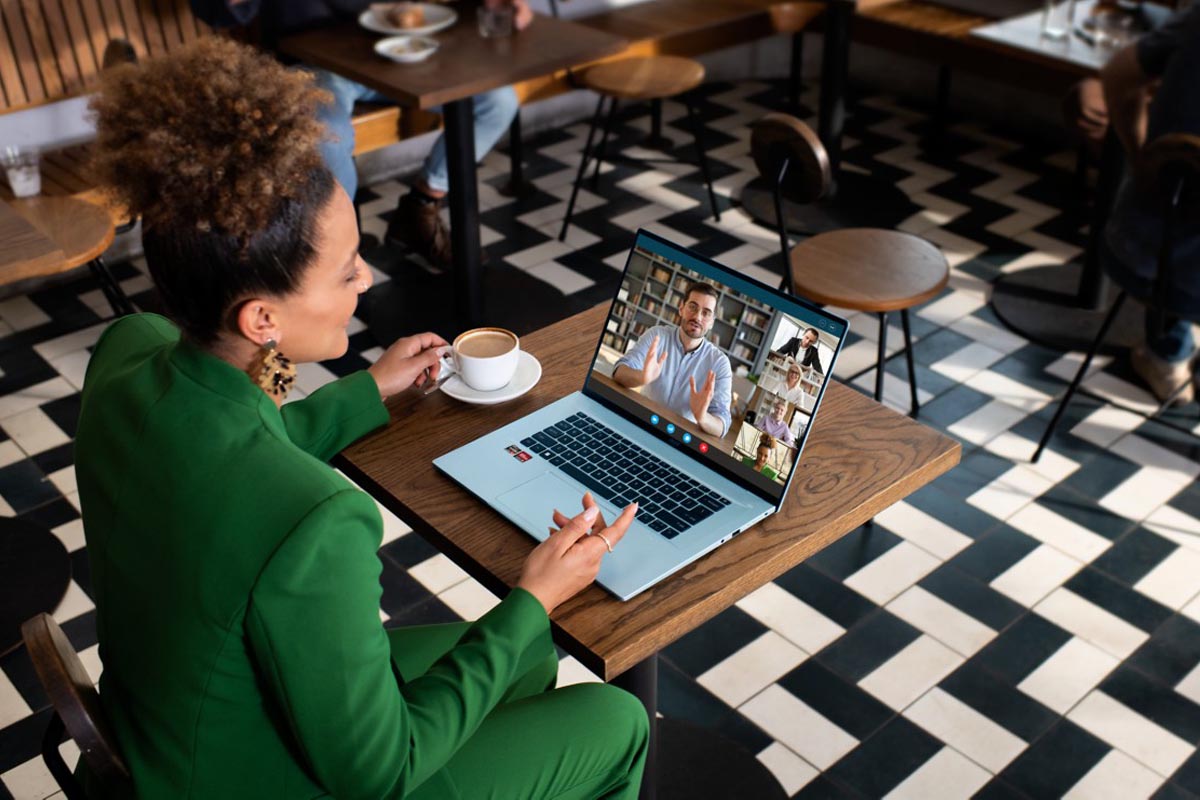 Frau sitzt an einem Tisch mit dem Laptop Acer Swift Edge