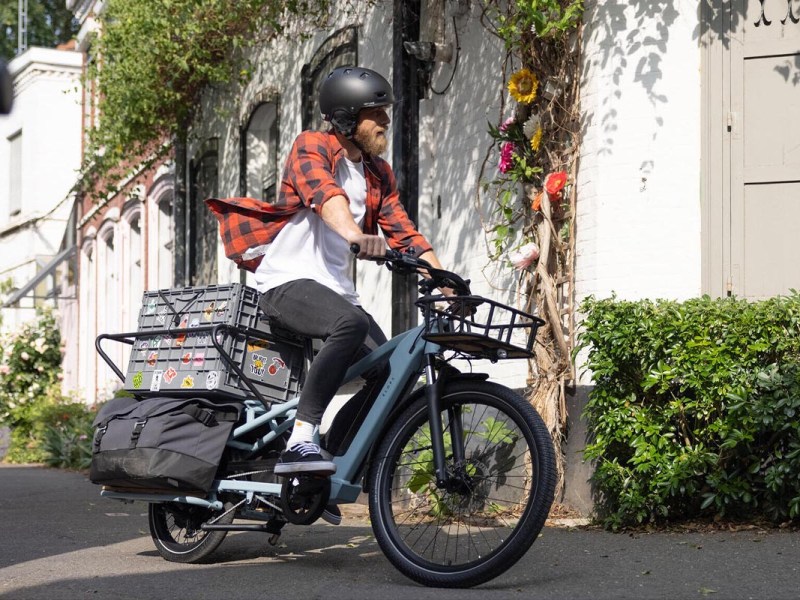 Ein Mann fährt draußen auf dem Decathlon Cargobike R500E Longtail