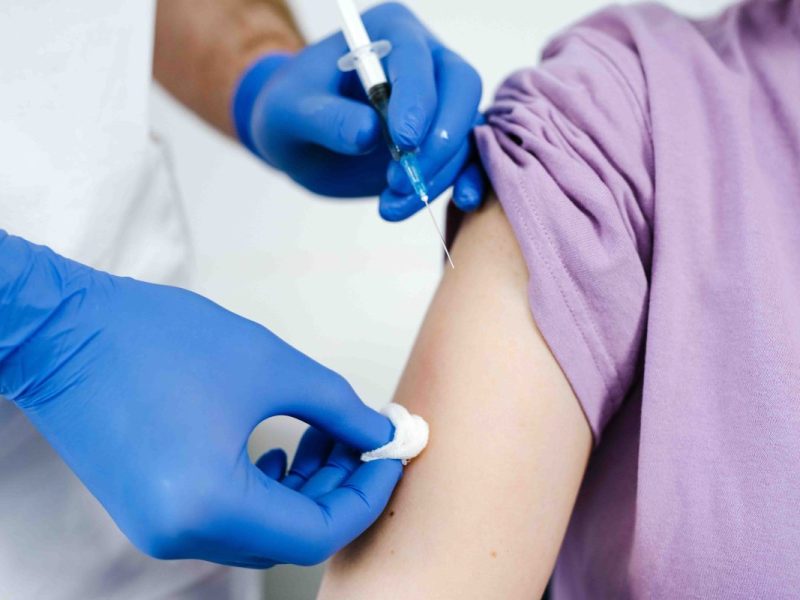 Ein Krankenpfleger verabreicht einem Kind eine Impfung.