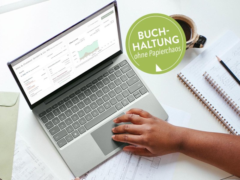 Laptop auf einem Tisch mit Notizblöcken daneben