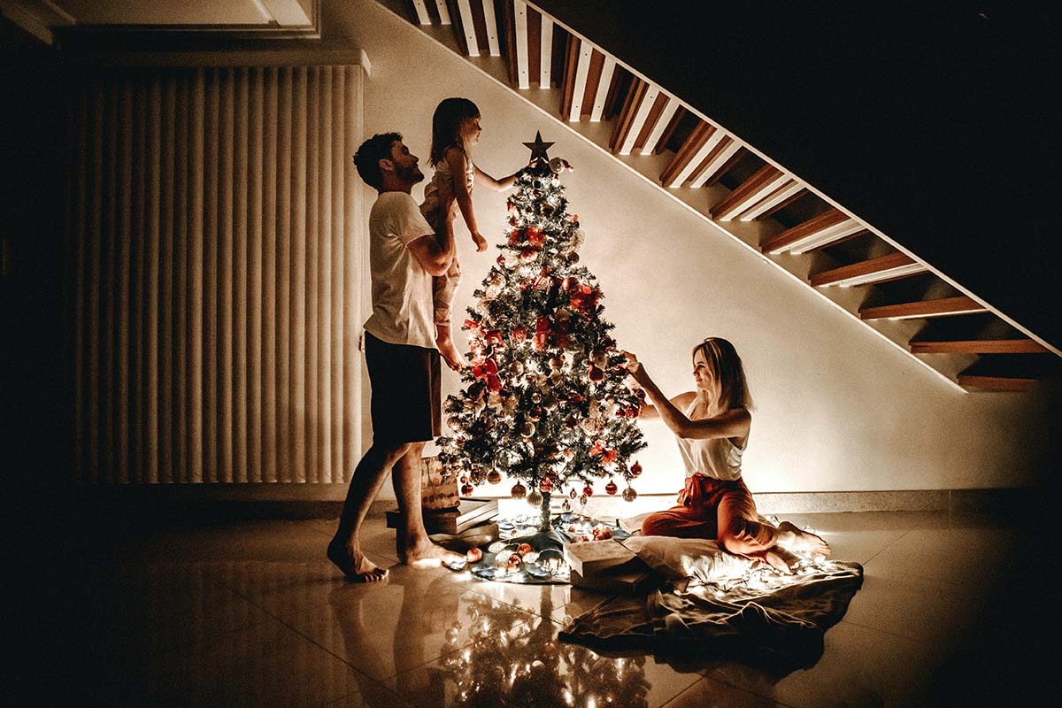 Eine Familie schmückt einen Weihnachtsbaum.