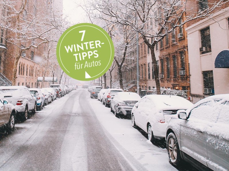 Auto winterfest machen: Verschneite Autos an einer Straße in der Stadt im Winter