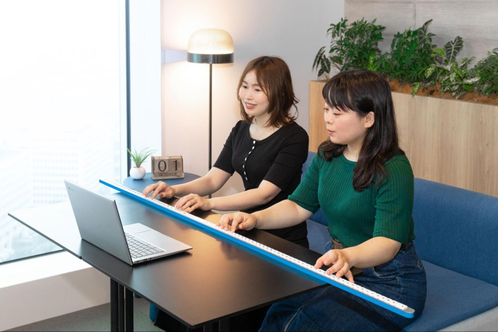 Zwei Frauen arbeiten an einer Tastatur