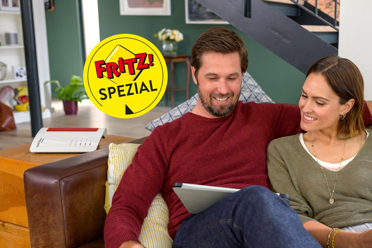 Mann und Frau sitzen auf dem Sofa mit Tablet in der Hand daneben steht eine FritzBox