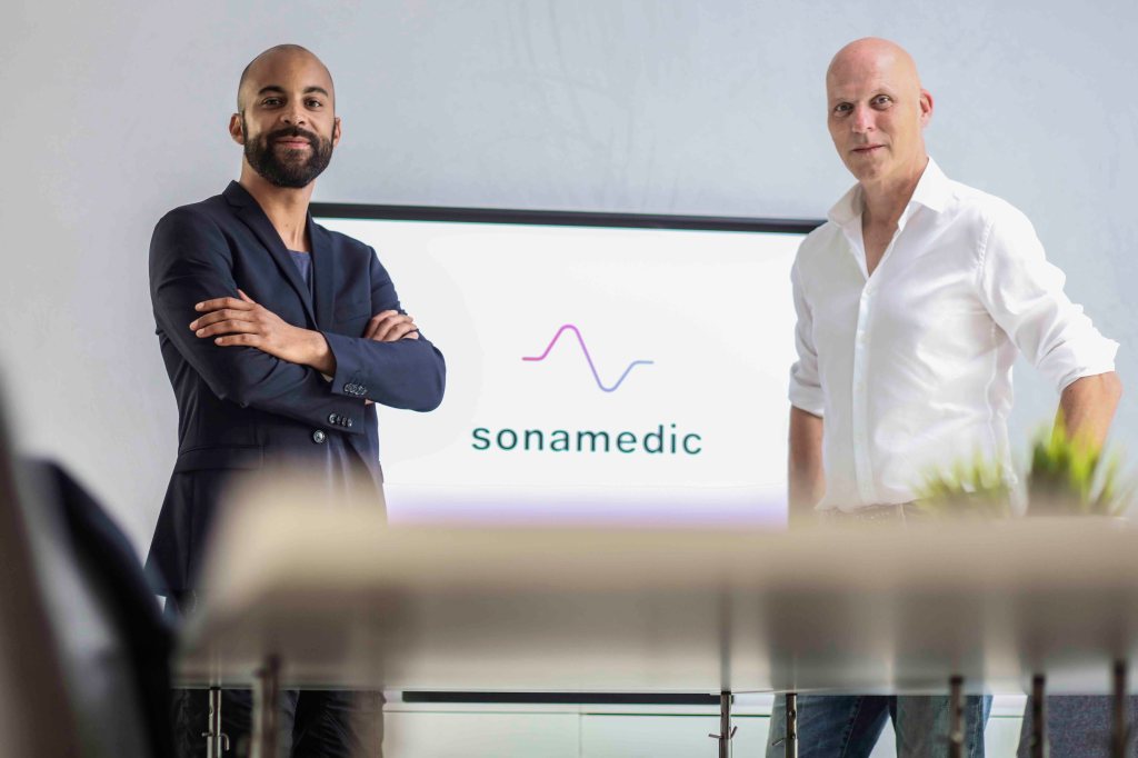 Zwei Gründer von Sonamedic stehen vor einem Bildschirm. 