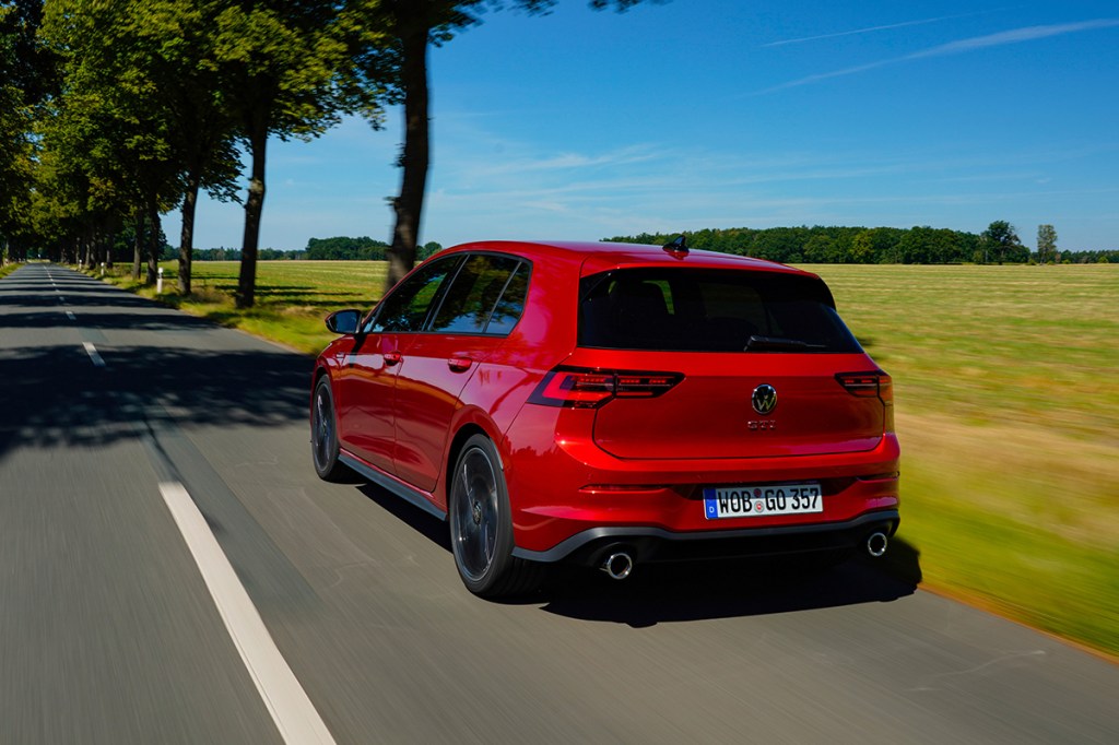 Volkswagen Golf von hinten, in Naturkulisse fahrend