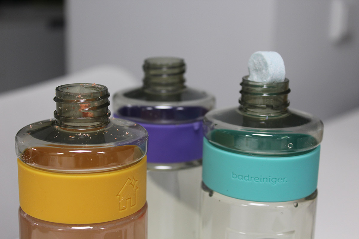 Produktbild der drei Reinigungsflaschen von smol mit einer Tablette.