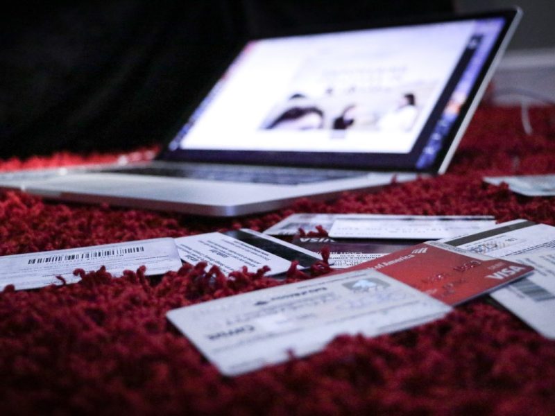 Kreditkarten liegen vor einem aufgeklappten Laptop.