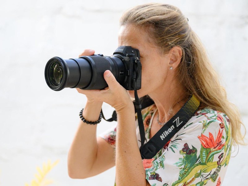 Eine Frau hält die Kamera mit dem Nikkor Megazoom ans Auge