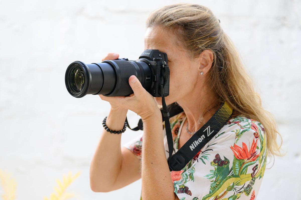 Eine Frau hält die Kamera mit dem Nikkor Megazoom ans Auge