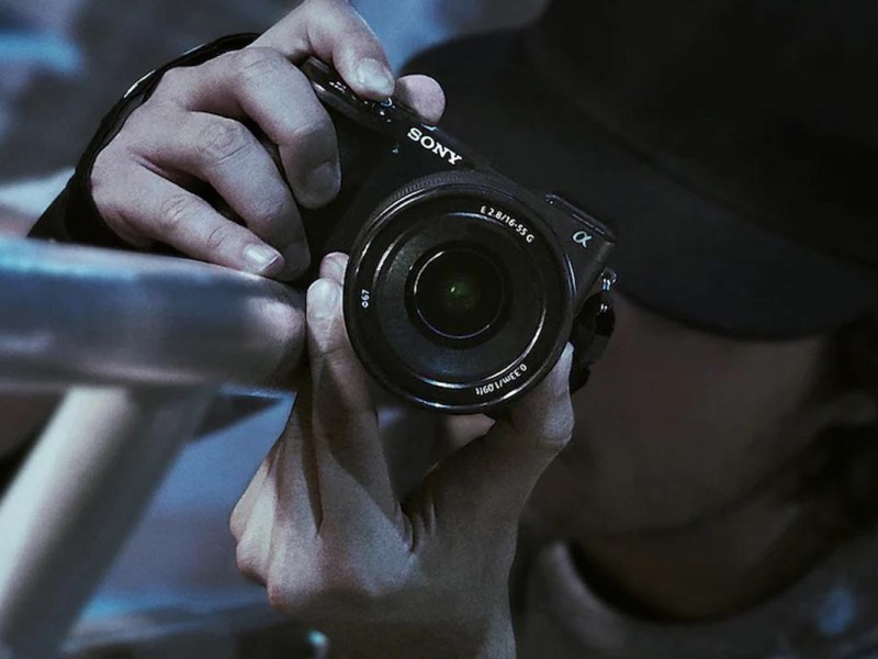 Ein Fotograf fotografiert mit der Kamera entlang eines Geländers