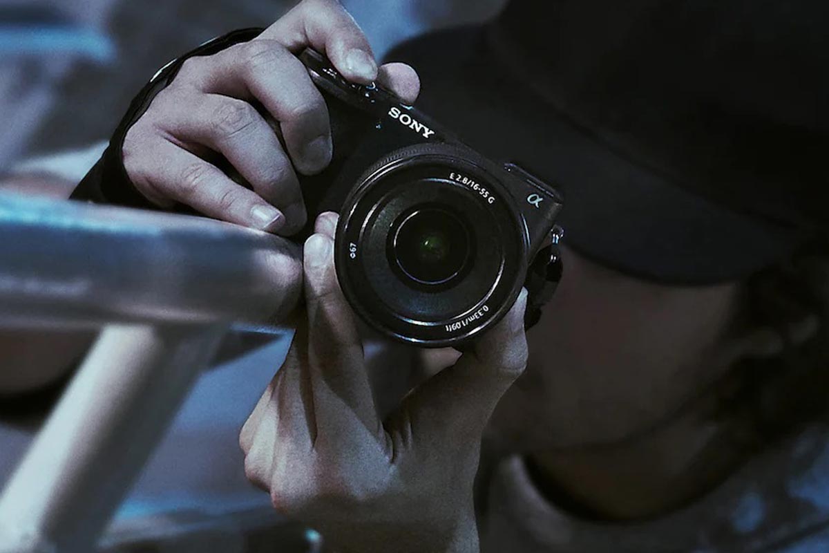 Ein Fotograf fotografiert mit der Kamera entlang eines Geländers