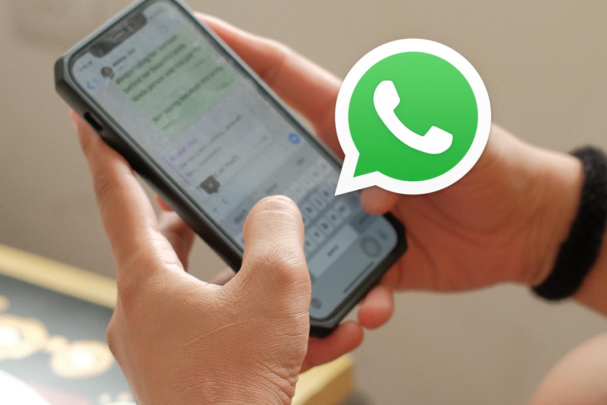 Jemand tippt auf Smartphone, Whatsapp-Icon im Vordergrund