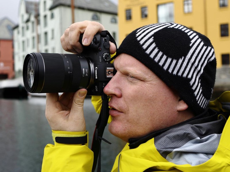 Ein Fotograf fotografiert mit dem Objektiv in einer Stadt
