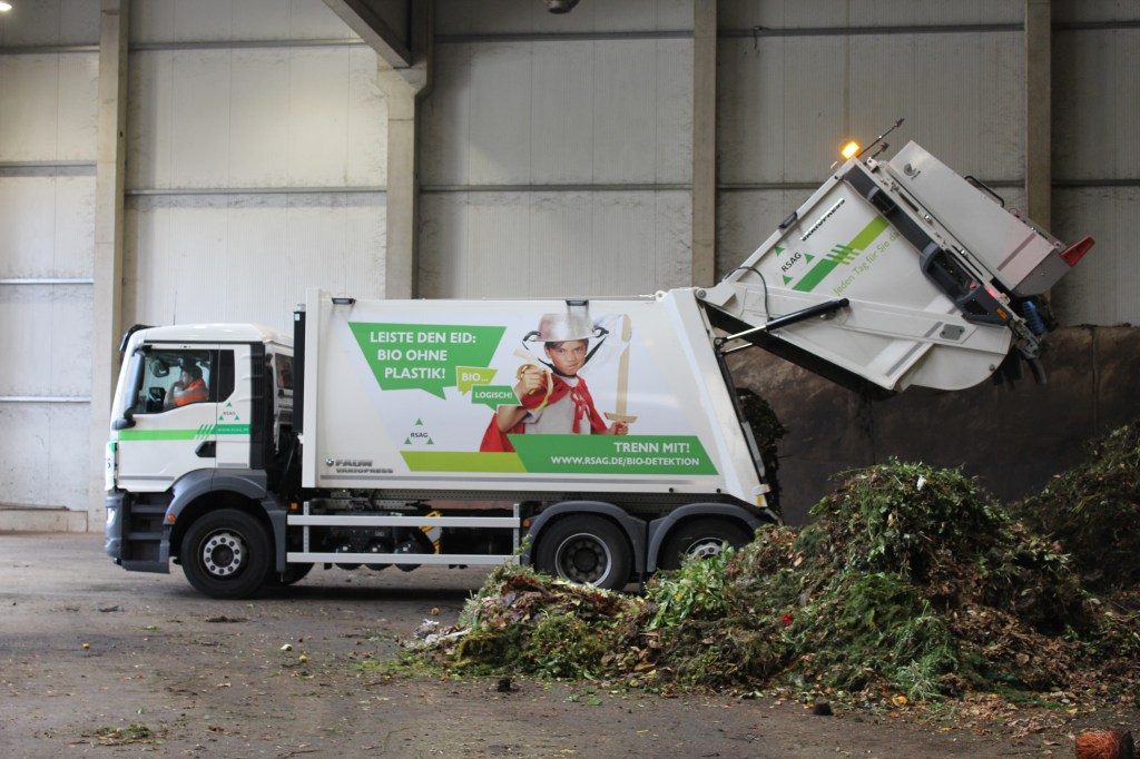 Ein LKW mit einer Ladung Biomüll in einer Halle.