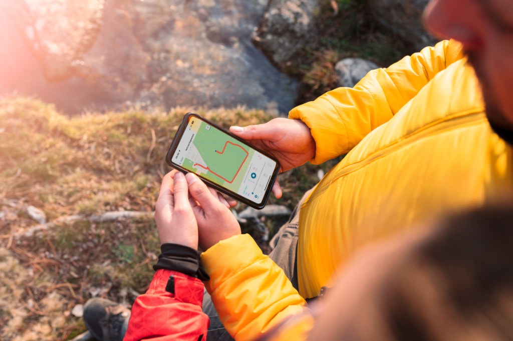 Hände halten Smartphone mit grünem Bild