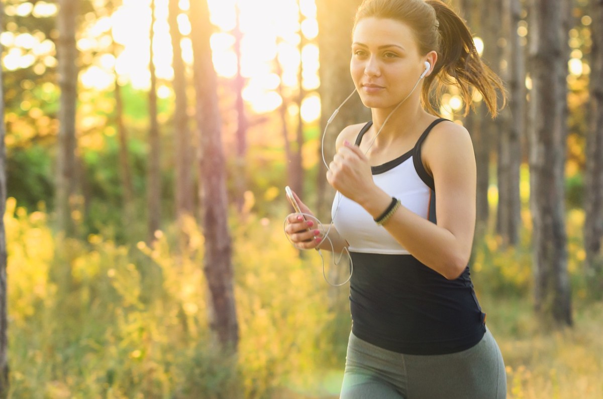 Frau joggt durch sonnige Landschaft