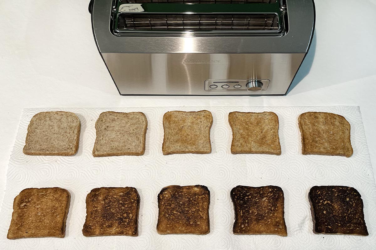 Zwei Fünferreihen Toast unterschiedlich gebräunt, oben im Bild silberner Toaster