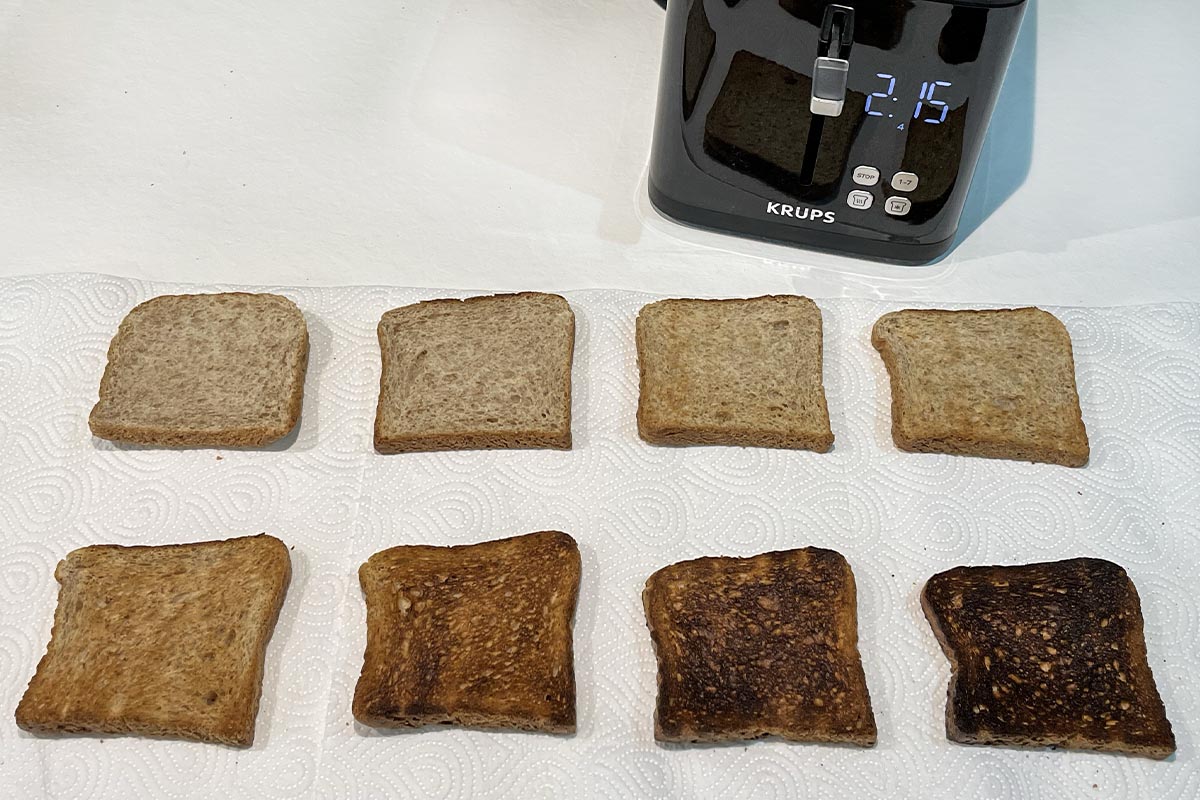 Zwei Viererreihen Toast unterschiedlich gebräunt oben im Bild schwarzer Toaster