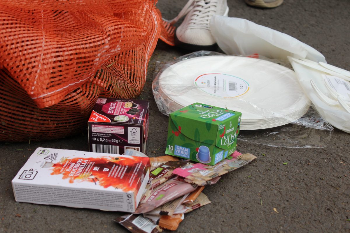 Verschiedene Verpackungen aus Bioplastik liegen auf dem Boden verteilt.