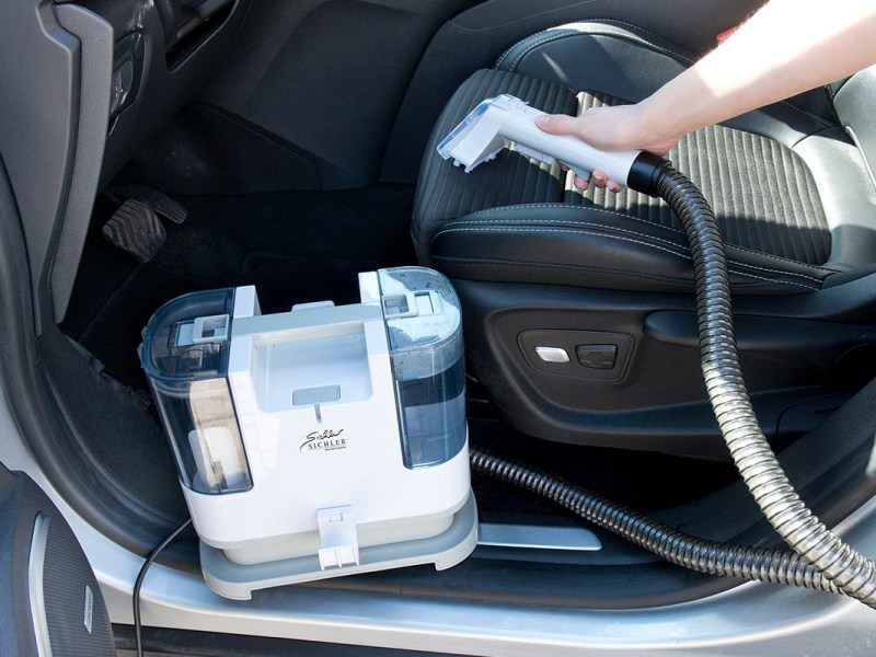 Ein Autositz wird mit dem Waschsauger gereinigt.