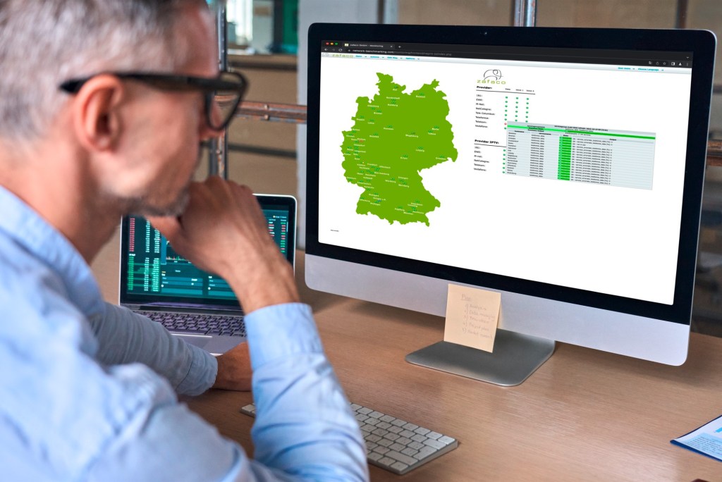 Mit dem Blick über die Schulter eines Mannes auf seinen Computer Zu sehen sind eine kleine Deutschlandkarte und Messwerte der Mobilfunkmessung.