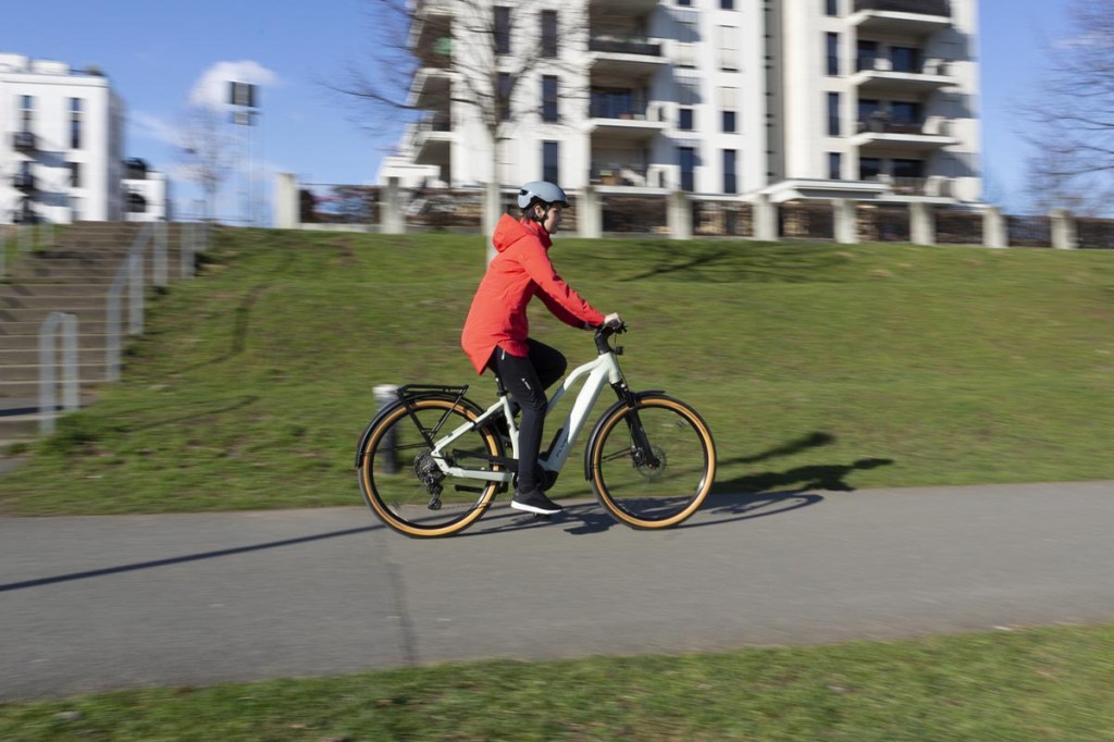 Frau fährt mit einem E-Bike auf einer Fahrradstraße